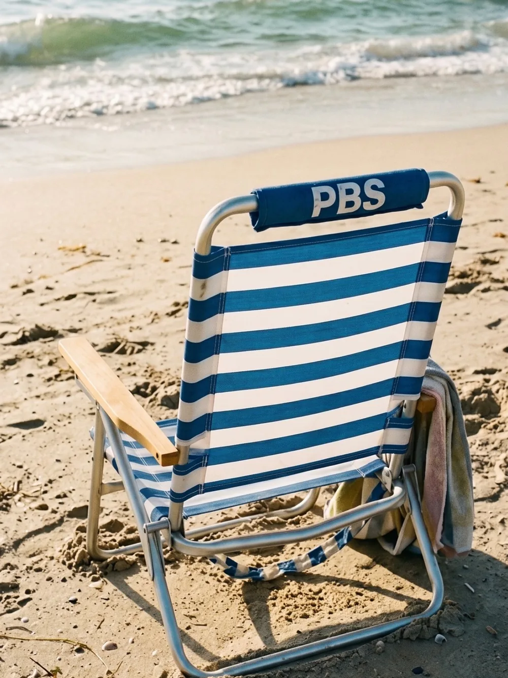 Blau-weiß gestreifter Strandstuhl am Wasser